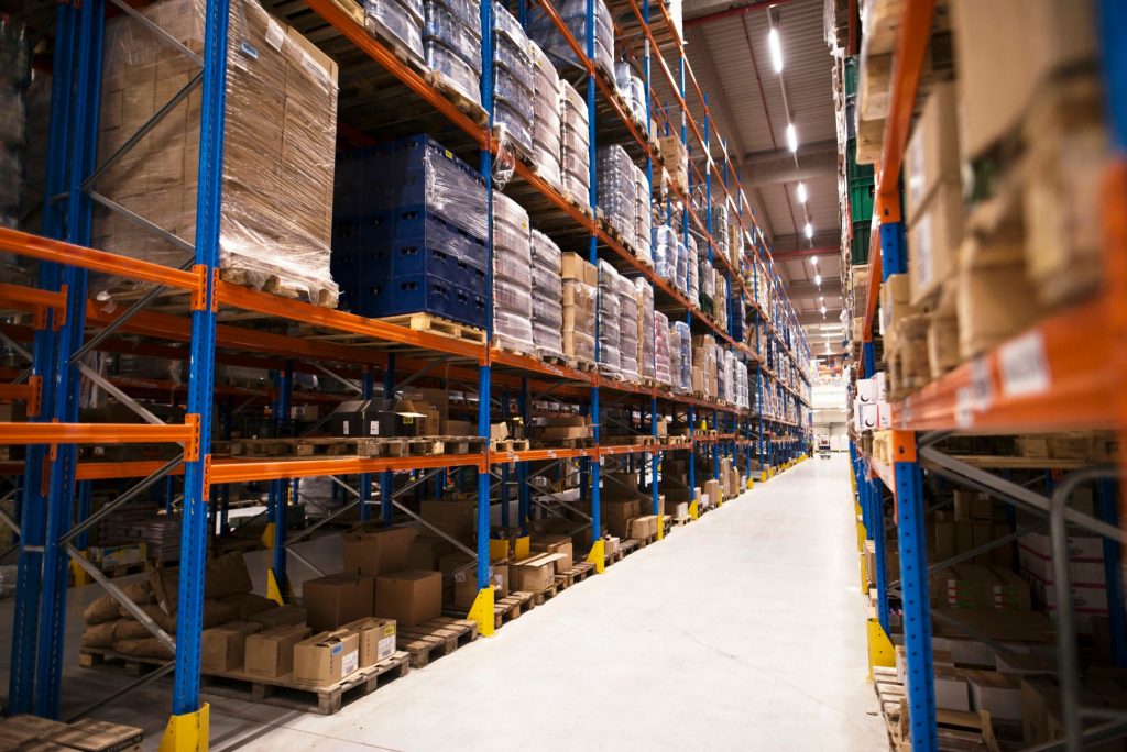 Interior of large distribution warehouse with shelves stacked with palettes