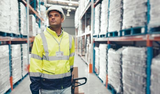 Logistics man and trolley in warehouse with packaging storage and shelf