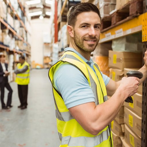 warehouse-worker-scanning-box-while-smiling-camera.jpg